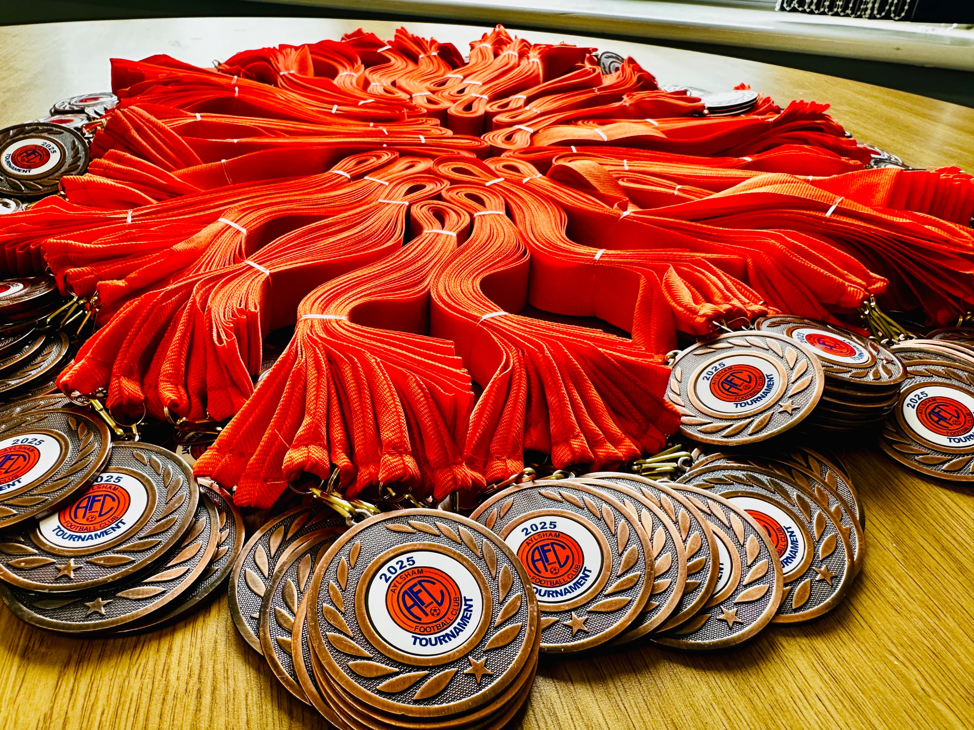 Tournament medals with red ribbons supplied by Hewitt's Trophies